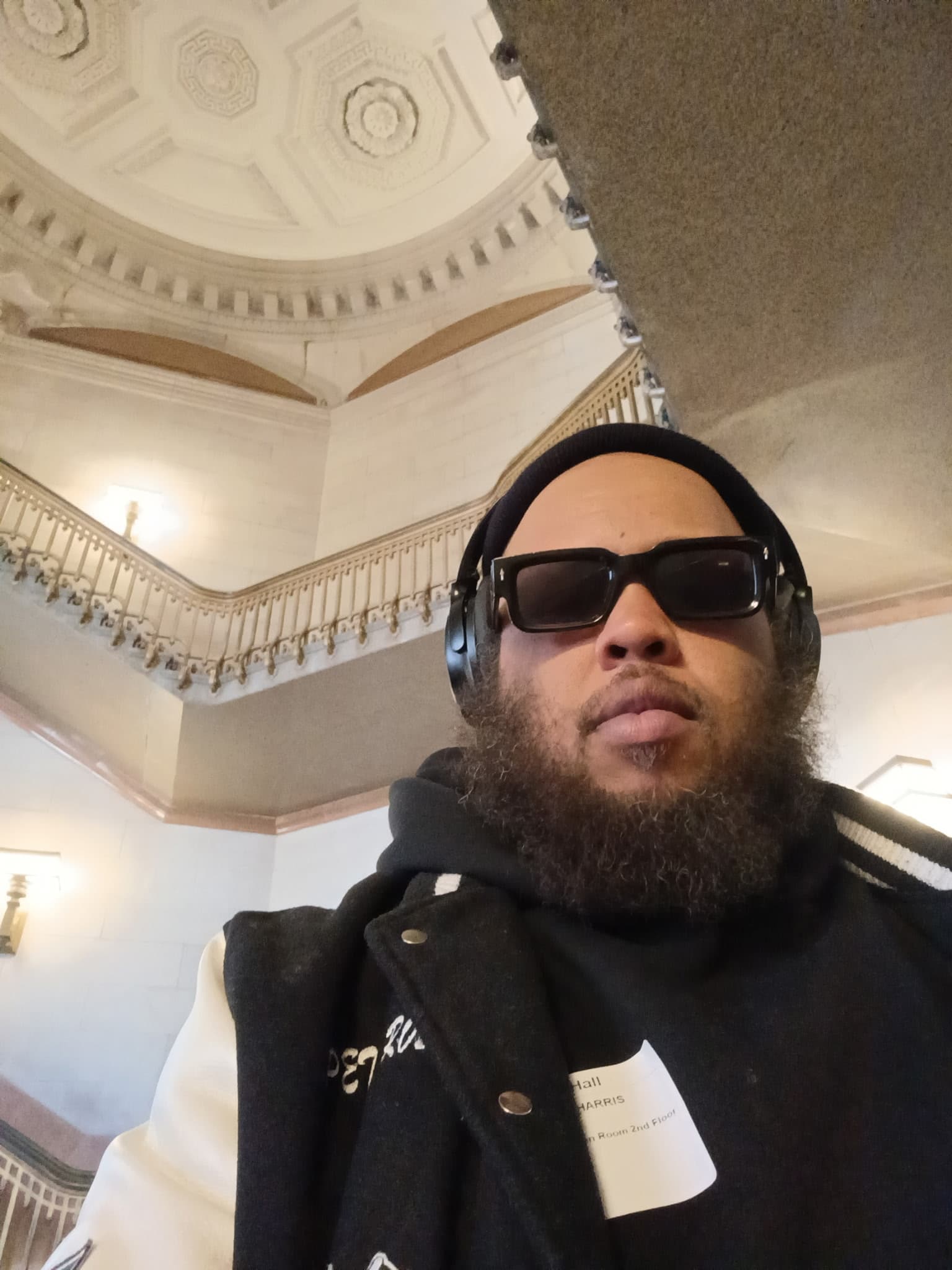 Pete Rose wearing sunglasses, headphones, and a beanie, face fully visible